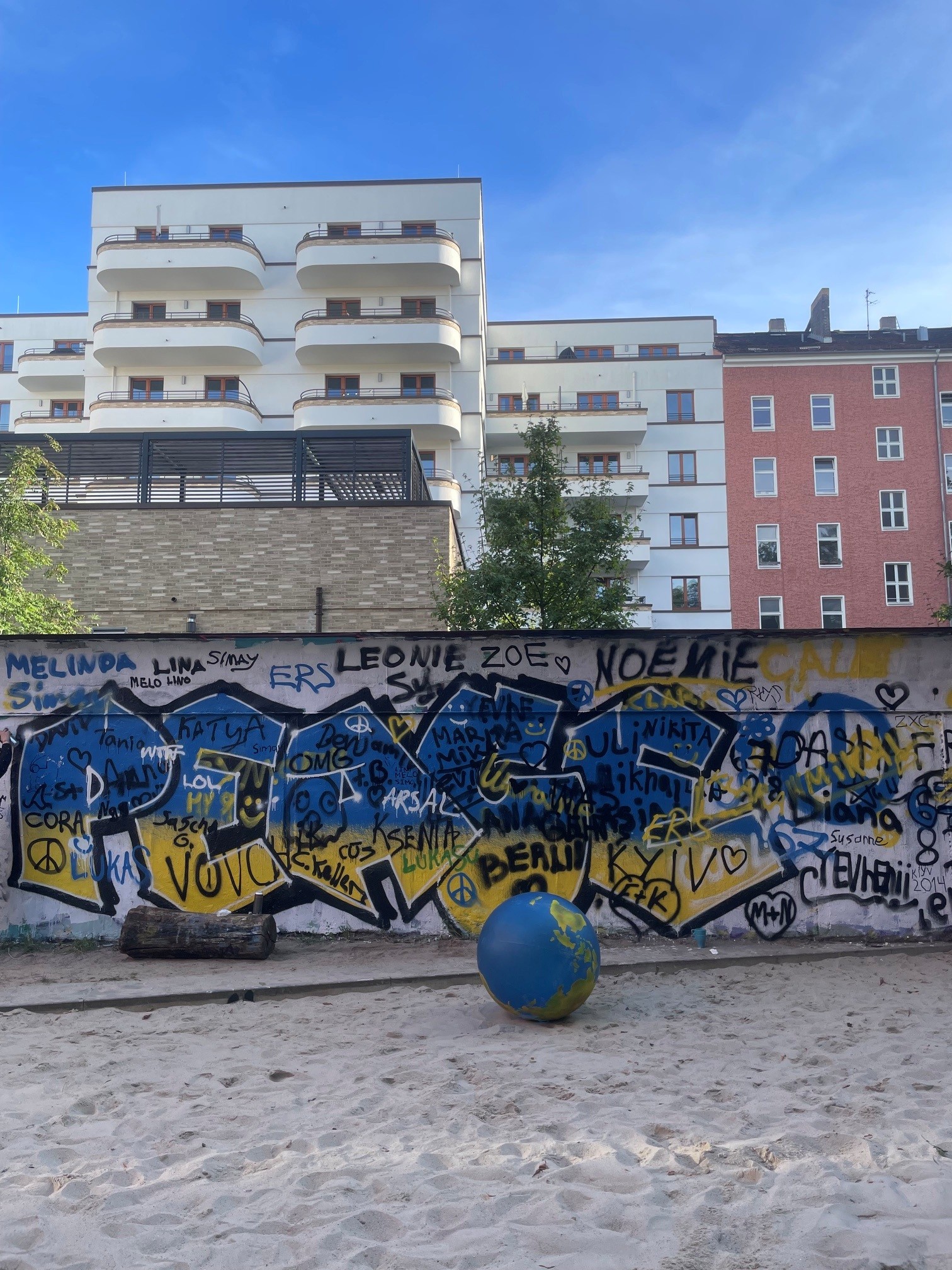 Graffiti mit dem Schriftzug Peace in blau/gelb